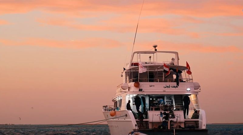 Safari jachta kotví pod oranžovým nebem při západu slunce